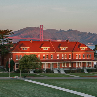 Lodge at the Presidio at sunset with the golden gate bridge in the distance