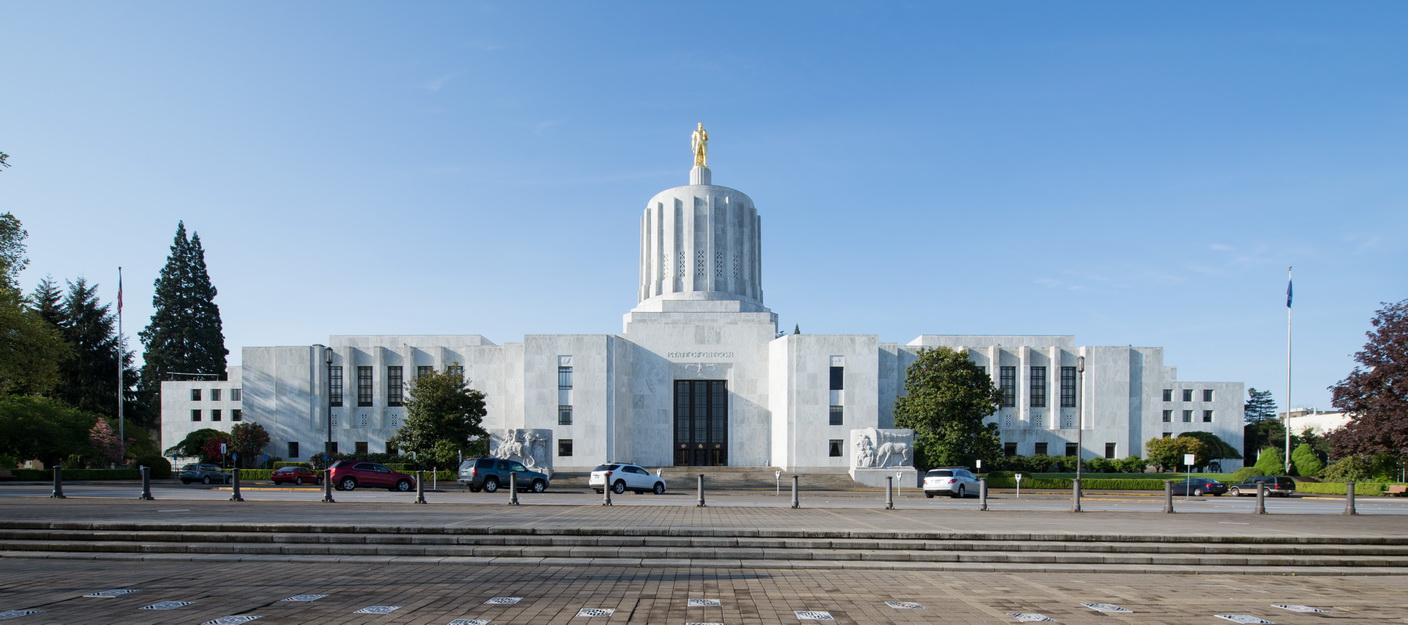 Front image of a the Oregon Capitol with cars insight and blue skies