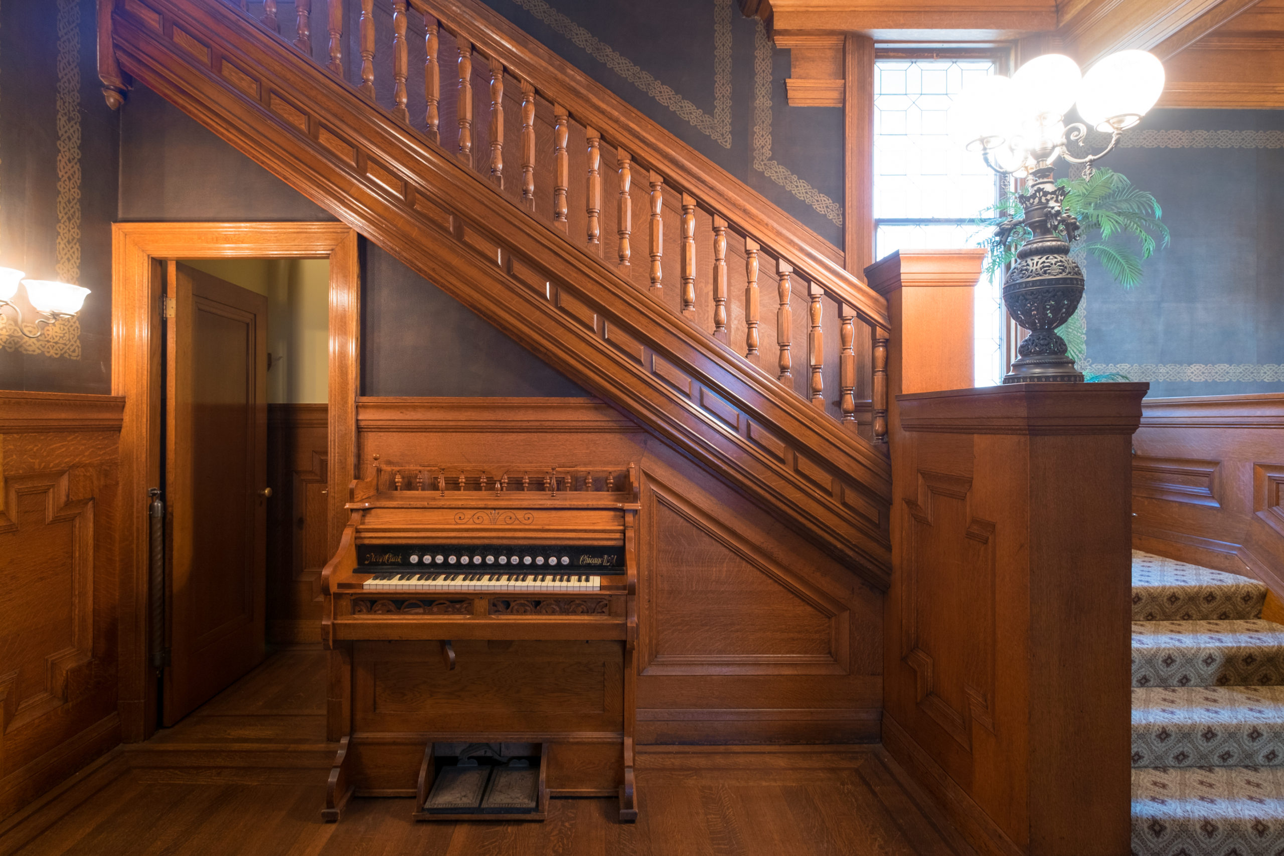 Interior image of wooden staircase and piano at Hass Lilienthal