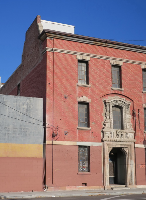 Brick building angle, entryway features a highly decorative cast stone detailing